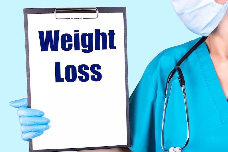 Doktor med skylt med Weight Loss